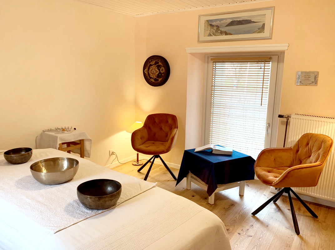 Un cabinet de soins holistiques, avec table de massage et bols tibértains
