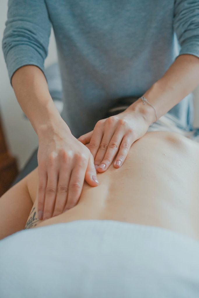 Gros plan sur des mains prodiguant un massage holistique.